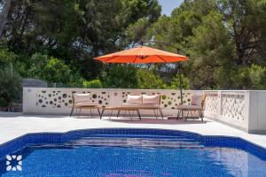 a patio with chairs and an umbrella next to a pool at Villa Corasol by Abahana Villas in Teulada +18 photos