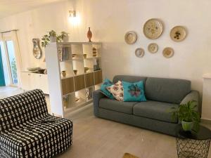 ein Wohnzimmer mit einem Sofa und einem Stuhl in der Unterkunft La Casa Blu in Mirabella Imbaccari