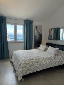 ein Schlafzimmer mit einem Bett und zwei Fenstern in der Unterkunft Villa Luce del Sole in Mirce