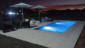 una piscina con sillas y sombrillas por la noche en Cvs, en Federación