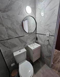 Un baño con inodoro, lavabo y espejo. en Cvs, en Federación