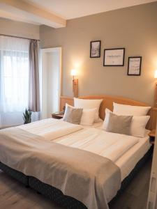 ein Schlafzimmer mit einem großen Bett mit weißer Bettwäsche und Kissen in der Unterkunft Weinstraße No 8 "Einfach-Gut-Übernachten" in Leinsweiler