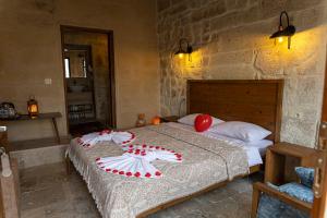 Schlafzimmer mit einem Bett mit roten und weißen Kissen in der Unterkunft Feris Cave Hotel in Nevşehir