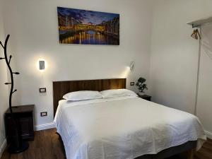 sypialnia z białym łóżkiem i obrazem na ścianie w obiekcie Annetta's House we Florencji