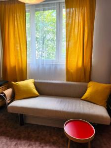 un sofá frente a una ventana con cortinas amarillas en Studio Centrum, Private Entrance, SELF CHECK-IN 24h en Katowice