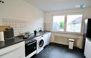 cocina con fregadero y lavadora en BEGE APARTMENTS Executive Lodgings, en Duisburg