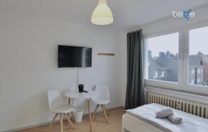 1 dormitorio con cama, mesa y ventana en BEGE APARTMENTS Executive Lodgings, en Duisburg