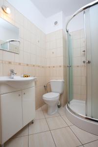 La salle de bains est pourvue d'un lavabo et d'une douche. dans l'établissement Willa Arielka, à Rewal