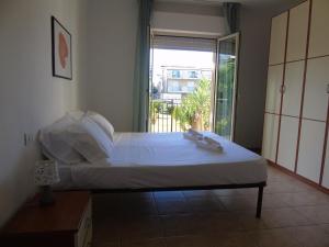 a bedroom with a bed and a door to a balcony at Homiday - Appartamenti Tamerici in Pineto