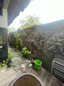 patio ze ścianą skalną i zielonym wiadrem w obiekcie Villa Watumita Sikka w mieście Hitokalak