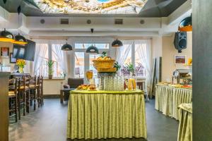 um restaurante com mesas com toalhas de mesa amarelas em Zefir SPA em Polańczyk