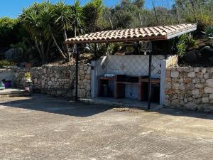 um edifício com uma parede de pedra e um abrigo em La Ginestra Vacanze em Castellammare del Golfo