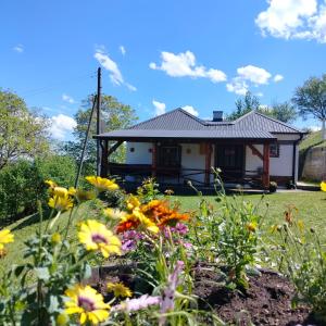 una casa con flores delante en Vujanac vikend kuća en Raška