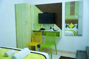 a bedroom with a desk with two chairs and a television at Park View Residency in Puducherry