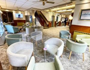 uma área de espera com cadeiras e mesas no átrio em Ruskin Hotel em Blackpool