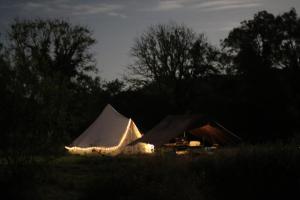 a tent with lights in a field at night at The Valley Bell Tents, Bring Your Own Bedding in Amroth