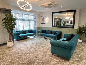a living room with blue couches and a mirror at Ruskin Hotel in Blackpool