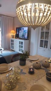 ein Wohnzimmer mit einem Tisch und einem Kronleuchter in der Unterkunft Apartamentos Boutique Mar De Cristal in Mar de Cristal