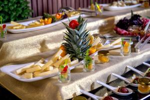a table with several plates of cheese and fruit at Happy Inn Gebze Hotel in Kocaeli