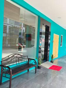 a bench in front of a building with a window at Red's Hotel in Bintulu