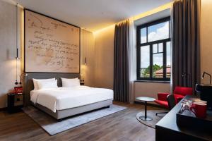 Un dormitorio con una cama y una pared con escritura. en Radisson RED Tbilisi en Tiflis