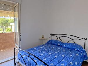 - un lit avec une couette bleue dans une chambre dans l'établissement La Perla di Luni Mare Casa Vacanze, à Fiumaretta di Ameglia