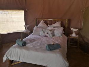a bed in a tent with two pillows on it at Luxury Tents Belabela Resort Warmbath in Bela-Bela