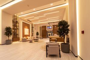 a lobby with chairs and couches in a building at Abidos Hotel Apartment Dubai Land in Dubai