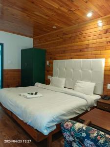 a bedroom with a large bed and a chair at Highland Heritage cottages in Manāli