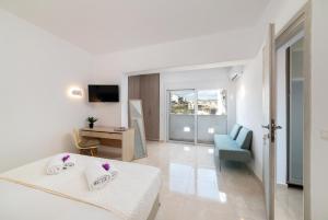 um quarto com uma cama, uma secretária e uma televisão em Loft 57 em Agios Nikolaos