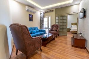 فندق اللوتس  في الأقصر: غرفة معيشة مع أريكة زرقاء وطاولة