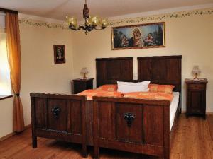 a bedroom with a large wooden bed with orange sheets at Ferienwohnung Hoacherer-Hof in Riedenburg