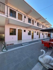 a building with a balcony with a table and chairs at Hotel Elsaidi in Velipojë