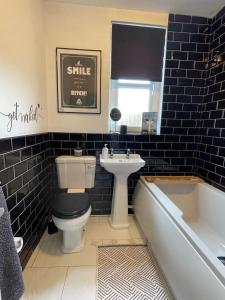 ein Badezimmer mit einem WC, einem Waschbecken und einer Badewanne in der Unterkunft Two bedroom ground floor apartment with garden in Falkirk
