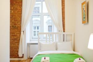 uma cama branca num quarto com uma janela em Danylo Inn em Lviv