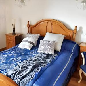 łóżko z niebiesko-białą pościelą i poduszkami w obiekcie 4 bedrooms house with jacuzzi and terrace at Zugarramurdi w mieście Zugarramurdi