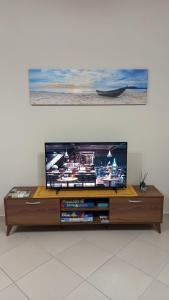 a flat screen tv sitting on top of a wooden entertainment center at Kasti's House 1 Vromolithos Beach in Vromolithos
