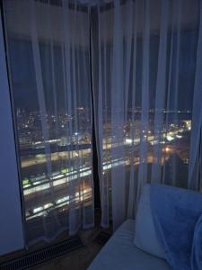 a bedroom with a window with a view of a city at apartmán 21-th floor Bratislava Petrzalka (building Vienna Gate) in Bratislava