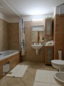 a bathroom with a tub and a sink and a toilet at apartmán 21-th floor Bratislava Petrzalka (building Vienna Gate) in Bratislava