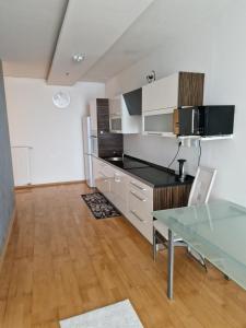 a kitchen with a glass table in a room at apartmán 21-th floor Bratislava Petrzalka (building Vienna Gate) in Bratislava