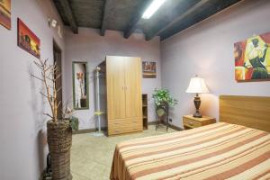 een slaapkamer met een bed, een kast en een lamp bij One bedroom house with enclosed garden and wifi at Castellammare del Golfo 2 km away from the beach in Castellammare del Golfo