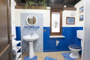 een blauwe en witte badkamer met een toilet en een wastafel bij One bedroom house with enclosed garden and wifi at Castellammare del Golfo 2 km away from the beach in Castellammare del Golfo