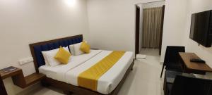 a bedroom with a bed and a desk and a television at Airport Regency in Devanahalli-Bangalore