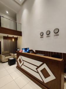 a lobby with two clocks on the wall at Airport Regency in Devanahalli-Bangalore