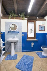 een blauwe badkamer met een wastafel en een toilet bij One bedroom house with enclosed garden and wifi at Castellammare del Golfo 2 km away from the beach in Castellammare del Golfo
