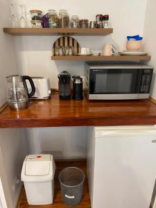 um balcão de cozinha com um micro-ondas numa bancada de madeira em Tree Lights Stay - Relaxing, Private Guest Suite em Perth