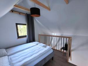 ein Schlafzimmer mit einem großen Bett und einem Fenster in der Unterkunft Osada Mrożynka in Rebiszów