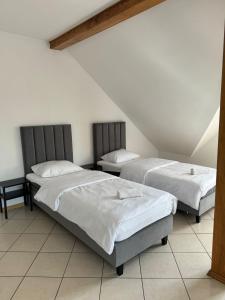 a bedroom with two beds in a attic at Hotelik Maria in Szczytno