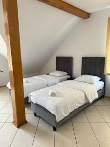 two beds in a room with a attic at Hotelik Maria in Szczytno