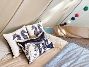 a bed with two pillows in a tent at Foxglove Field Glamping in Perranuthnoe